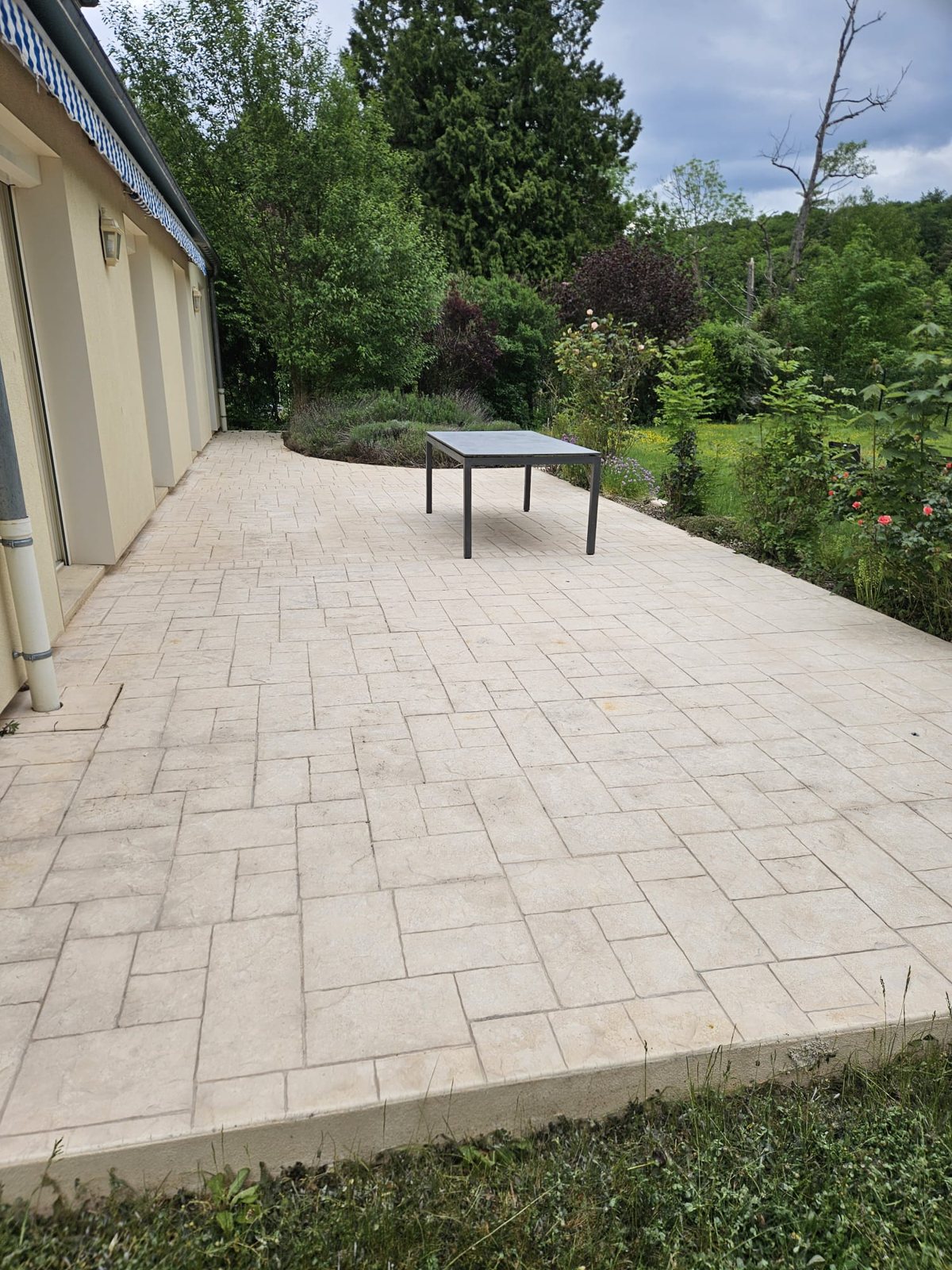 Après : la même terrasse, dalles claires.