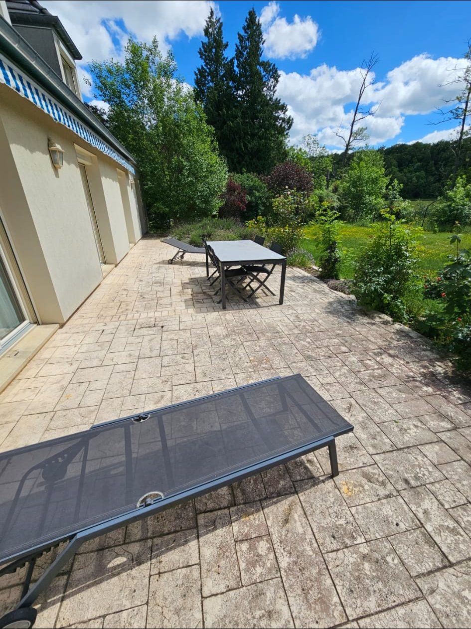 Avant : grande terrasse en dalles grises et tachées.
