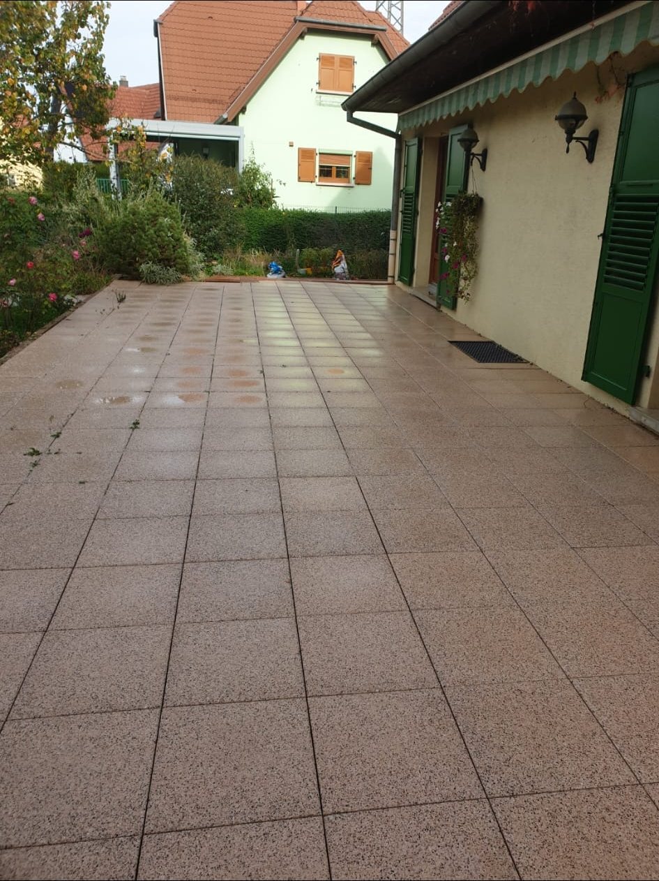 Après : la même terrasse, carrelage rosé et propre.
