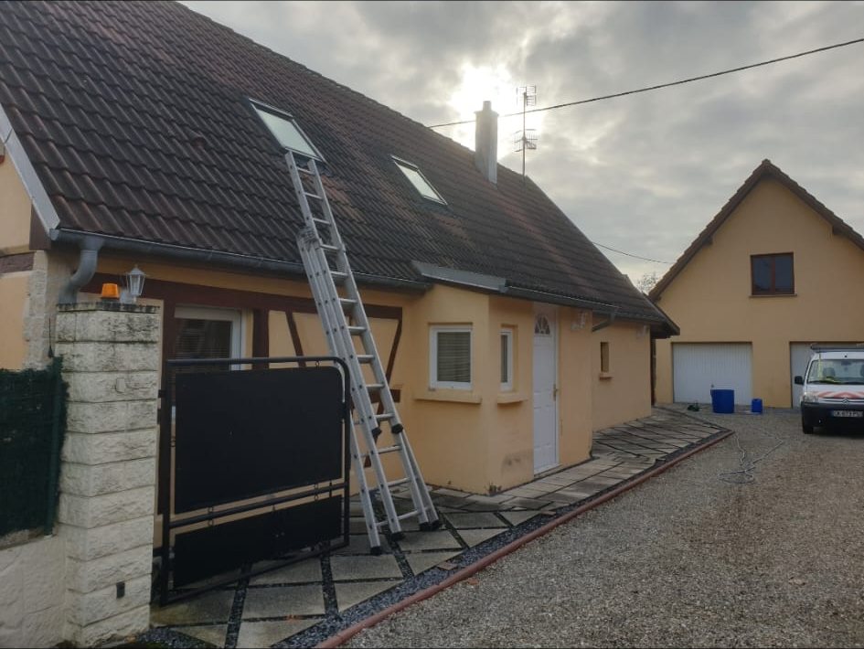 Avant : maison à colombages, toiture sombre, une échelle posée.